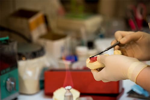 医院専用の歯科技工所で技工士が歯を仕上げている様子